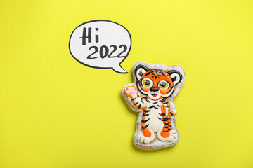 Cute cookie in shape of tiger for New Year 2022 on color background