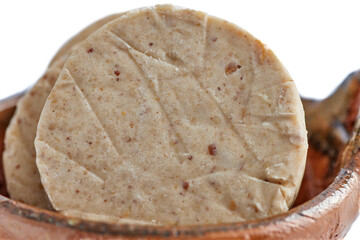 Dulces tradicionales mexicanos. Dulce de cacahuate llamado "Mazap&aacute;n" sobre una olla de barro en fondo blanco.
