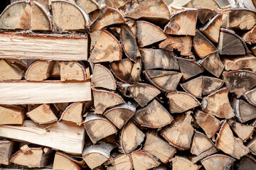 firewood background of chopped wood for kindling and heating the house Close-up. a woodpile with stacked firewood. the texture of the birch tree. banner