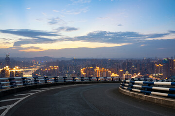 empty asphalt road with modern cityscape during sunset.
