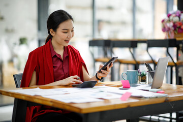 Professional young asian business woman using computer laptop and Talking On Phone Working On Laptop In Modern Office.	
