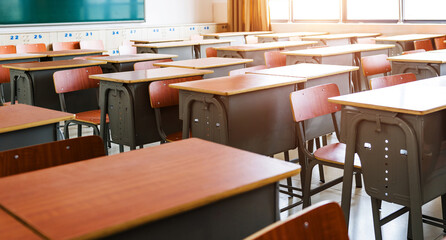 Empty classroom with desks, chairs and chalkboard
