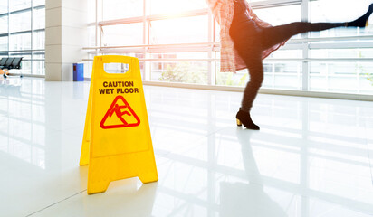 Woman slips next to the wet floor sign