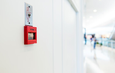 Red fire alarm on wall of shopping center - obrazy, fototapety, plakaty