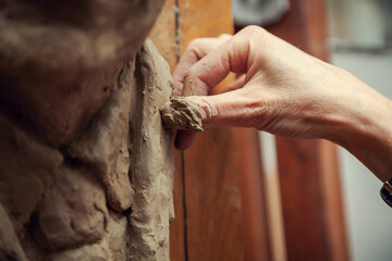 Woman sculptor at work. Sculptor's hand close up.