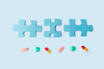 Blue jigsaw puzzle pieces with different pills and medicines. Concept of Neurological Disease Treatment : Autism, Alzheimer's, Dimension. Copy space for text. Awareness day. Supportive and Acceptance.