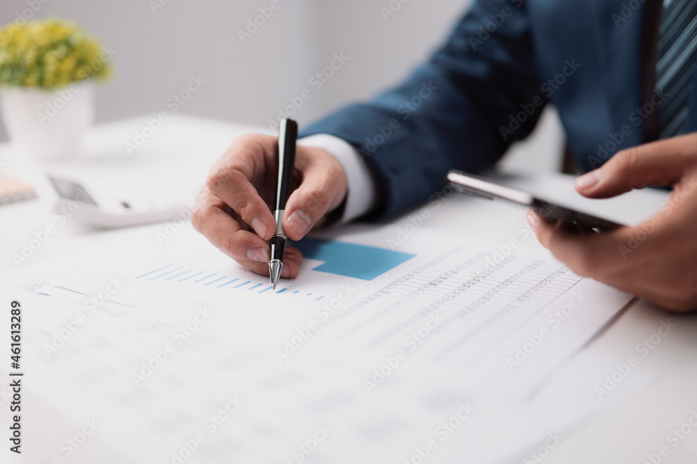 Poster Businessmen are using cellphones to get internet information and audit financial reports by examining the graphs in company reports. Analyzing income and analyzing the budget idea