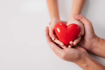 World heart day, world health day, CSR responsibility, adoption foster family, hope, gratitude, kind, concept, adult and child hands holding red heart, health care, donate and family insurance concept