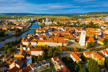Fototapeta na wymiar Aerial view of Old Town of Czech city of Pisek on Otava river overlooking white belfry of Church of Nativity 