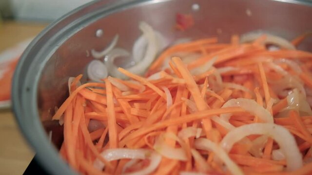 Delicious yam, carrots, tomato, and onion slices in cooking pot