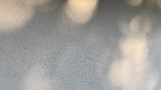 bokeh light on a wall. round nature sunlight reflect on cement wall. daytime light. shiny sun on surface. texture and background.