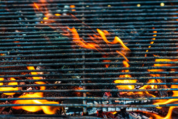 Empty hot charcoal barbecue grill with bright flame. Hot burning grill, outdoors cooking food
