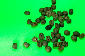 Scattered coffee beans with green background