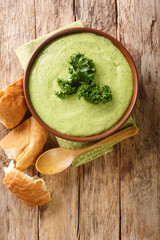 Diet cream soup puree made from kale cabbage close-up in a bowl on the table. vertical top view from above