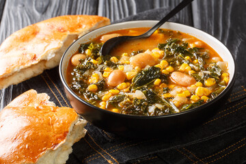 Black Sea Turkish vegetarian Kara lahana corbası spicy cabbage soup with kale, beans, tomatoes and corn close-up in a bowl on the table. horizontal