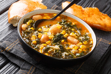 Vegetarian Turkish Kara lahana corbası spicy cabbage soup with kale, beans, tomatoes and corn close-up in a bowl on the table. horizontal