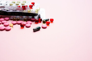 multicolored pills medicine pain reliever pink background