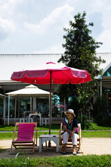 Asian travelers thai women people travel visit and sitting rest relaxed on deck chairs or lounge chair on small beach in garden park outdoor of cafe restaurant coffee shop at Bangkok of Thailand