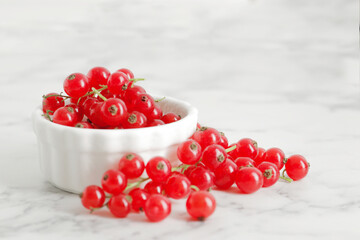 composition of ripe red currant berries on a textured marble background