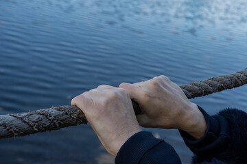 Female hands hold on to the rope.