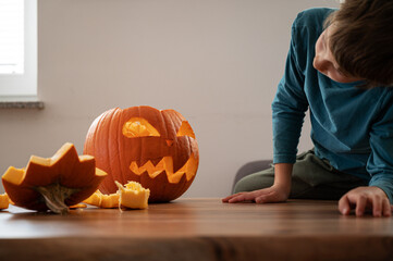 Boy looking at halloween pumpkin