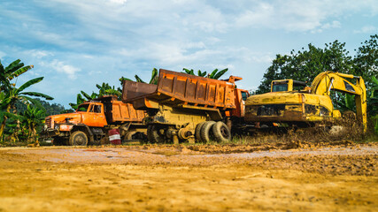 Fototapeta premium Wreck of heavy machinery in the junkyard of forestry company. Broken old rusty truck and excavator