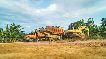 Fototapeta premium Wreck of heavy machinery in the junkyard of forestry company. Broken old rusty truck and excavator