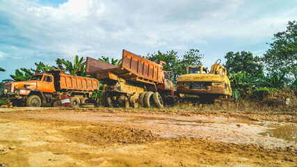 Fototapeta premium Wreck of heavy machinery in the junkyard of forestry company. Broken old rusty truck and excavator