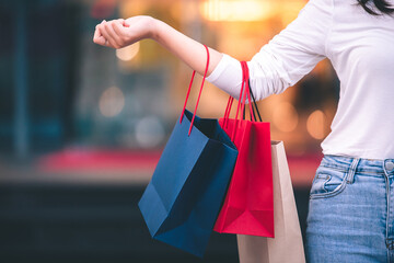 fashion shopping girl A young woman carries a colorful shopping bag as she walks along a shopping mall.