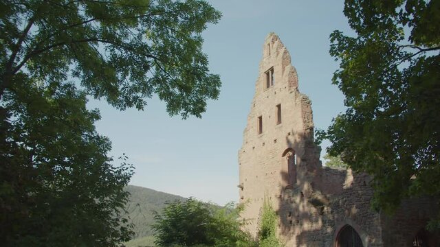Viewing Stone Ruin of Limbach Monastery through Green Forest on Summer Day