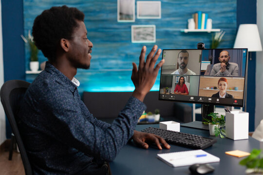 Business student greeting university team on videocall meeting conference using school e-learning platform during coronavirus lockdown in living room. Online videoconference telework call on screen