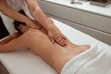Obraz na płótnie Canvas Professional masseuse massaging female back in spa salon