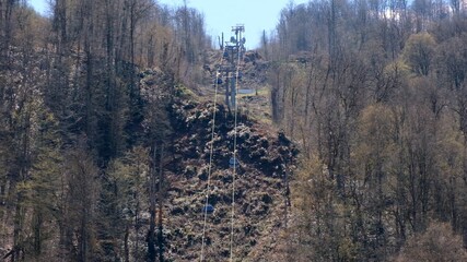 Cable chair ski lift in Gorky Gorod mountain ski resort in Caucasus mountains on Krasnaya Polyana, Sochi, Russia. Scenic autumn landscape.