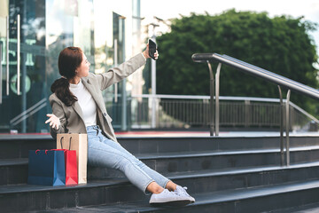 Shopping, lifestyle concepts young women with colorful shopping bags and smartphones enjoying shopping
