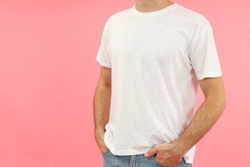 Young man in white t-shirt on pink background