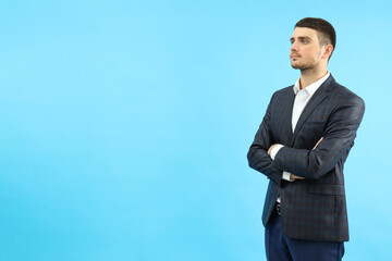 Young businessman on blue background, space for text