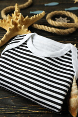 Marine concept of baby clothes on wooden background