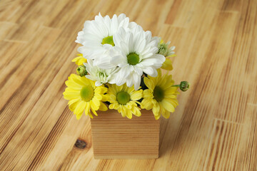 Mini box with chrysanthemums on wooden background