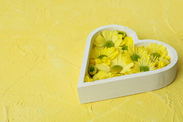 Heart with chrysanthemums on yellow textured background