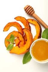 Baked pumpkin, mint, honey and dipper on white background