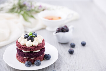 Blueberry cheesecake on white plate on wooden table, birthday party, corporate event or wedding celebration