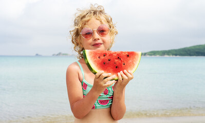 Portrait little girl licking fresh watermelon slice posing on beach having fun and positive emotion