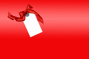 white tag with a red bow on a red background
