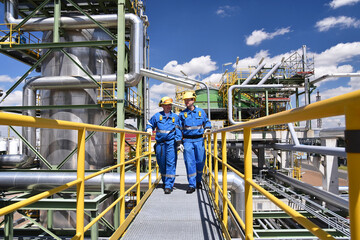chemical industry plant - workers in work clothes in a refinery with pipes and machinery - 461638253
