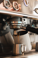 steel coffee machine in a cafe pouring hot coffee into a metal mug