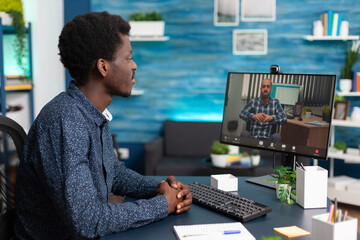 Black student discussing marketing strategy with remote university teacher on school e-learning platform during online videocall meeting conference. Videoconference telework call on computer