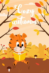 A cute cartoon tiger is reading a book in an autumn forest with yellow bushes, mushrooms and fallen leaves. Vertical rectangular card with an adorable character.Cozy autumn. Color vector illustration.