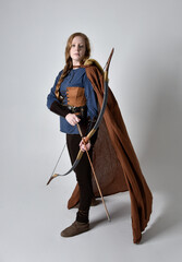 
Full length, portrait of red haired woman wearing medieval viking inspired costume and flowing...
