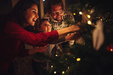 Fototapeta Family decorating Christmas tree at home obraz