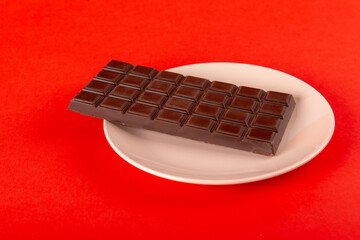 Chocolate with plate on red background